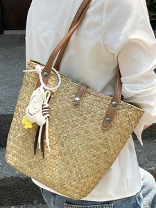 Handmade straw tote bag with brown leather straps and a cute white duck pendant