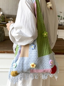 Bohemian crochet tote bag with colorful 3D flowers and long fringe in a lifestyle setting