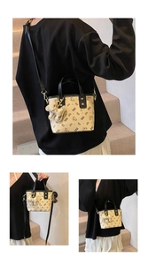 Detail of mini beige bucket bag with bear print, showing handbag and crossbody styles