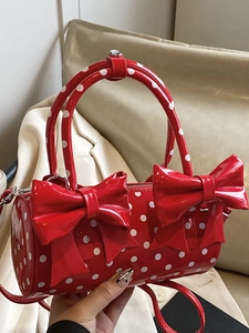 Sac cylindrique rouge à pois avec nœuds et finition en cuir verni brillant
