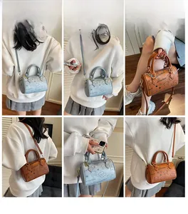 Detail showing various carry modes of the bear print Boston bag in blue and caramel