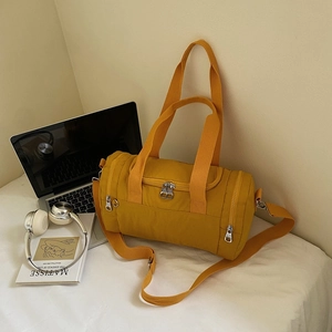 Close-up of a yellow nylon duffel bag with durable straps and side zipper pockets