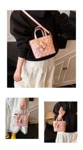 Detail view of pink bear pattern handbag showing the cute charm and golden hardware