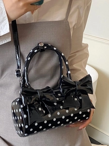 Sac cylindrique à pois en cuir verni noir avec des nœuds et une bandoulière réglable