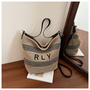 Détail du sac cabas en paille RLY avec rayures noires et bandoulière en cuir fin