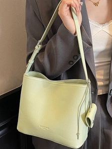 Chic pistachio green leather bucket bag with adjustable strap and small coin purse