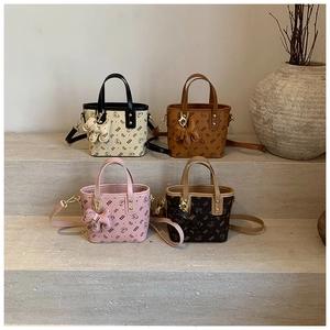 Close-up of mini bucket bags in four colors with cartoon bear prints and dog charms
