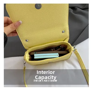 Interior view of yellow leather bag showing storage for phone and wallet with magnetic buckle