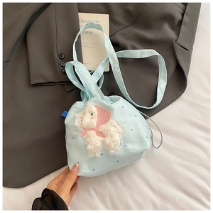 Dettaglio della borsa a secchiello azzurra a pois con agnello di peluche 3D e sciarpa rosa