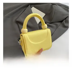 Close-up of bright yellow litchi grain texture bag with sphere handle detail