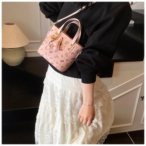 Detail of pink fashion handbag with black bear print and cute bear charm accessory