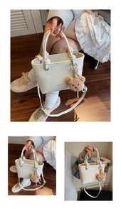 Detail of white lychee textured tote bag with round handle and plush bear pendant