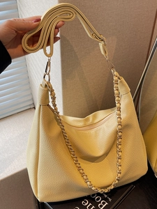 Creamy yellow pebble leather hobo bag with gold chain strap and adjustable crossbody belt