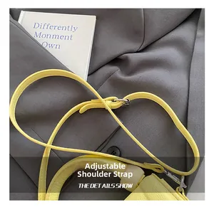 Detail view of light yellow litchi grain leather adjustable shoulder strap with silver buckle