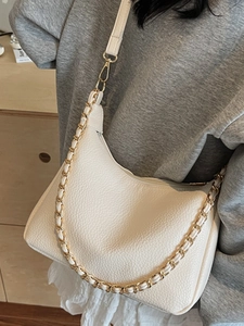 Chic cream dumpling hobo bag with gold chain and leather strap in crossbody style
