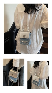 Detail of a mini crossbody bag with butterfly buckle and elegant pearl chain handle