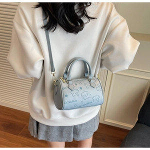 Detail of light blue Boston bag featuring cute cartoon bear patterns and sturdy dual handles
