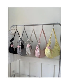 Fünf Nylon-Halbmondtaschen am Ständer mit Herzanhängern und gestreiften Gurten