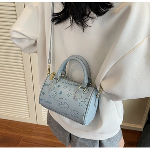 Detailed view of light blue Boston bag with cute bear prints and gold hardware
