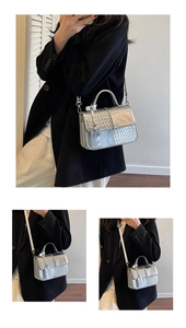 Detail of silver metallic handbag with woven texture flap and sleek handle