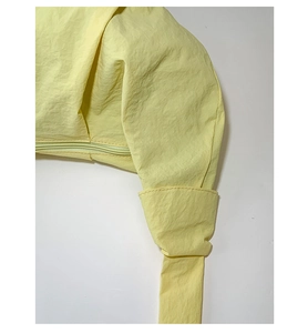 Detail of macaron yellow dumpling bag showing strap stitching and smooth nylon texture