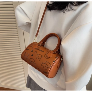 Caramel Boston bag with cartoon prints shown as a crossbody on a model's side