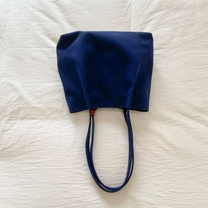 Detailed view of dark blue canvas tote bag showing thick fabric and long flat handles