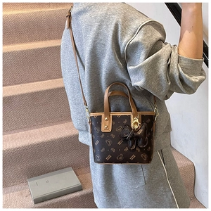 Detail view of dark brown PU bucket bag with bear pattern print and cute bear charm