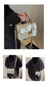Detail view of gold woven handbag with metallic handles and a detachable shoulder strap
