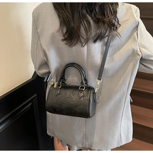 Detailed view of the black Boston bag with 3D bear embossing and golden hardware