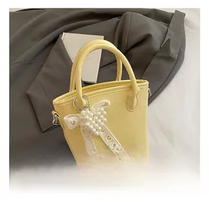Detailansicht hellgelbe Beuteltasche mit Knitterleder-Optik und Perlen-Schleifen-Anhänger