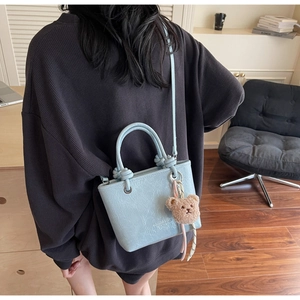Light blue lychee textured tote bag with a cute brown plush bear charm and crossbody strap