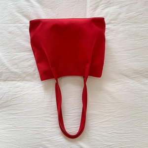 Detail of red heavy-duty canvas tote showing fabric texture and reinforced handles
