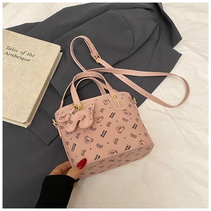 Detailed macro view of pink PU bucket bag with bear patterns and cute charm attachment