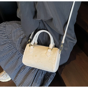 Detail of cream Boston bag with bear and dog embossing and Shiyinman text detail