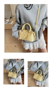 Dettaglio della mini borsa Boston trapuntata giallo chiaro con borchie e cuciture a onda