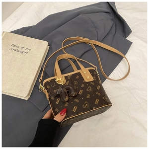 Detail view of brown vintage basket bag featuring cartoon bear prints and gold hardware