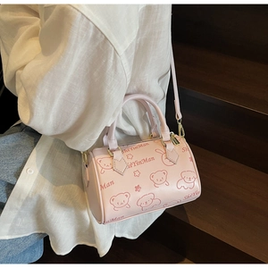Detail of pink Boston bag with cartoon bear pattern and gold-tone zipper hardware