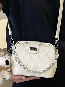 Chic beige quilted crossbody bag with silver chain strap and plush puppy charm
