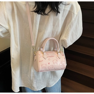 Detail of pink Boston bag showing cartoon prints and adjustable shoulder strap style