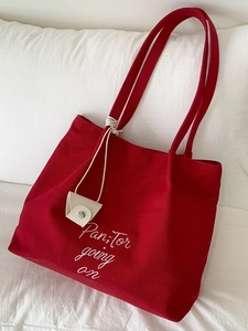 Red canvas tote bag with white embroidery and matching small triangle coin purse hanging