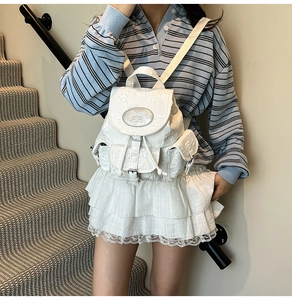 Vue détaillée d'un sac à dos blanc en similicuir avec motif papillon 3D et rabat frontal