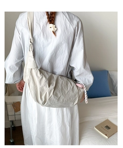 Detailed back view of a beige crescent crossbody bag in lightweight nylon fabric
