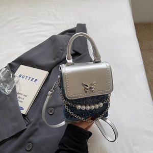 Detail of silver flap and denim mini bag with metal butterfly buckle and pearl chain
