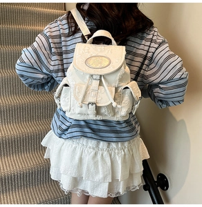 Détail d'un sac à dos blanc de style coréen avec broderie florale et boucle métallique