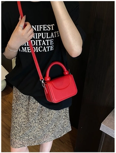Chic red lychee leather handbag with silver hardware and round handle on female model