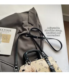 Nahaufnahme des verstellbaren Lederriemens und Plüschbär-Anhängers an der Tasche