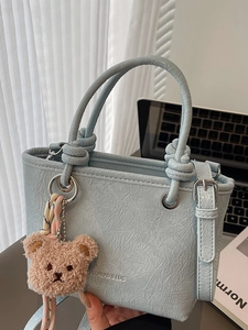 Light blue pleated leather handbag with adjustable strap and cute brown teddy bear charm