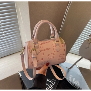 Detail of pink Boston bag with cute cartoon bear embossing and gold-tone metal hardware