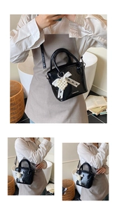 Detail der schwarzen Lackleder-Beuteltasche mit Spitze, Perle und Modedruckmotiv